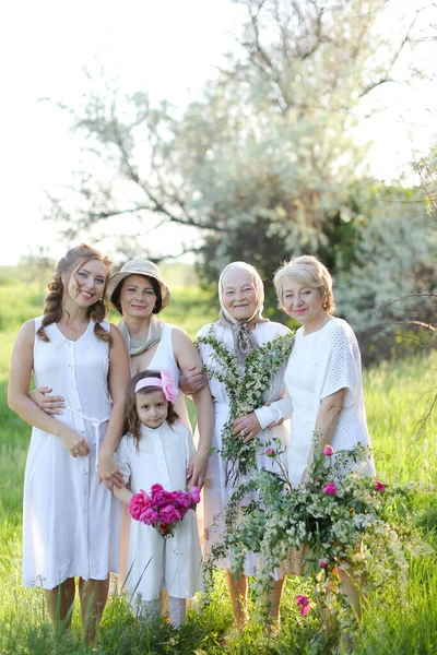 Caucasian grandmother in white dress with daughters and granddaughters outside. — Stock Photo, Image
