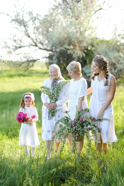 Szczęśliwy biały babcia w biały sukienka z córka i wnuczki na zewnątrz. — Zdjęcie stockowe