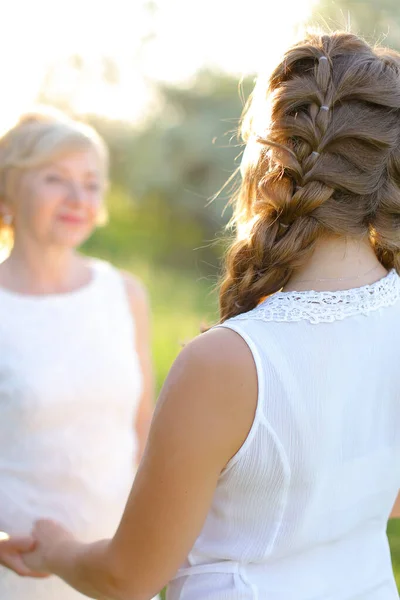 Focus on back view girl holding mother hands outside. — Stock Photo, Image