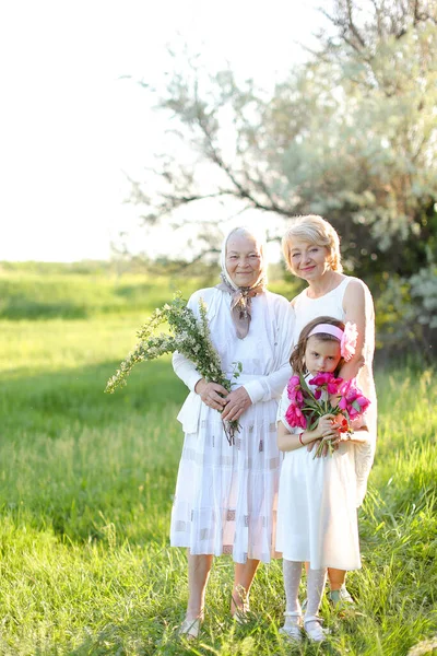 American grandmother in white dress with daughter and granddaughter outside. — Stock Photo, Image