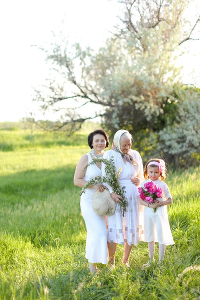 European old grandmother in white dress with daughter and granddaughter outside. — Stock Photo, Image