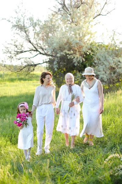 Old granny walking in park with daughter and granddaughter. — Stock Photo, Image