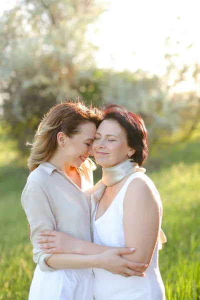 Portrait of girl hugging mother in park and wearing white clothes. — Stock Photo, Image