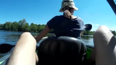 Genç bir kadın ve bir adam kanoda kürek çekiyor. Ukrayna, Güney Böcek Nehri, Khmelnytskyi POV aksiyon kamerası