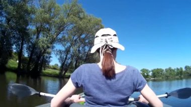 Genç bir kadın ve bir adam kanoda kürek çekiyor. Ukrayna, Güney Böcek Nehri, Khmelnytskyi POV aksiyon kamerası