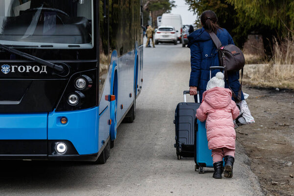 Uzhhorod, Ukraine - February 26, 2022: Ukrainian refugee with a child leave the country on the Slovak border fleeing Russian aggression against Ukraine.