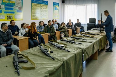 Uzhhorod, Ukraine - March 3, 2022: Local people learn the basics of handling firearms. Defense of Ukraine from Russian aggression. clipart