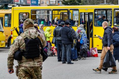 Uzhhorod, Ukrayna - 9 Mart 2022: Rus askeri saldırısından kaçan Ukraynalı mülteciler, şehir meydanlarından birinde Slovakya ve Macaristan sınırlarını geçmek için bir otobüs bekliyorlar.
