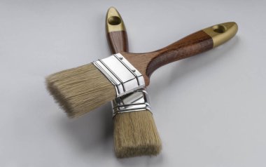 Beyaz arka planda iki tahta boya fırçası.