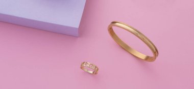 Pastel renklerde modern altın bilezik ve yüzük.