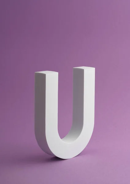 コピースペースと紫の色の背景に白い文字Uオブジェクトの垂直ショット — ストック写真