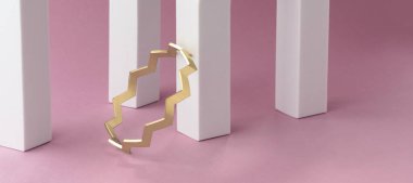 Zigzag şekilli altın bilezik pembe arkaplandaki beyaz sütunlara yerleştirilmiş.