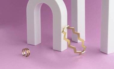 Zigzag şekilli altın bilezik ve yüzük beyaz kemerde ve sütunlar mor arkaplanda