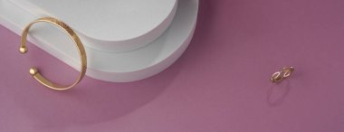 Geometrik desenli bilezik panoraması ve beyaz ve pembe arka planda fotokopi alanı ile halka