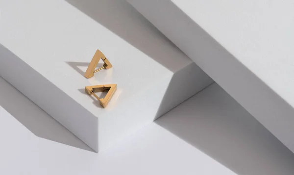 Widok z góry Triangle nowoczesne kolczyki pary na minimalnym geometrycznym białym tle z miejsca kopiowania — Zdjęcie stockowe