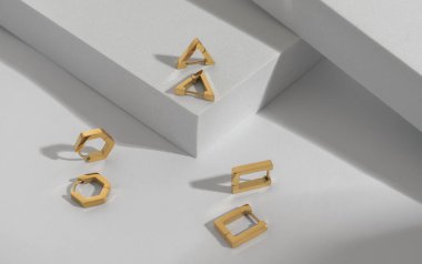 Üç modern geometrik şekilli küpe beyaz arka planda fotokopi alanı ile çift