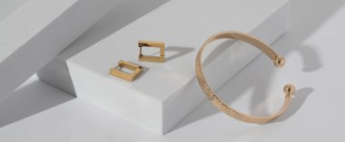 Geometrik beyaz arka planda modern bilezik ve küpe panoraması