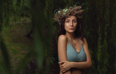 Ormanda fotokopi aletiyle defne çelengi giyen güzel bir kadın.