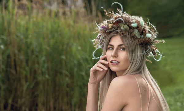 Pretty woman wearing head flower wreath in nature