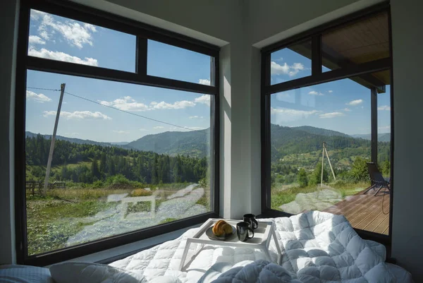 Bed with big windows and stunning mountains view with copy space