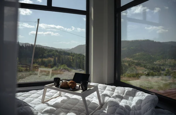 Breakfast table on a bed with panoramic mountain view with copy space