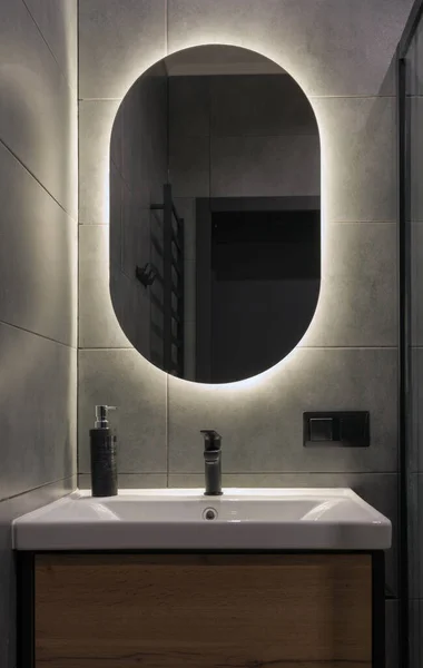 Vorderseite Des Modernen Ovalen Badezimmerspiegels Mit Hintergrundbeleuchtung Mit Kopierraum Stockbild