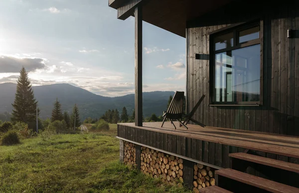 Schwarze Holzstühle Auf Der Terrasse Mit Bergblick Bei Sonnenuntergang lizenzfreie Stockbilder