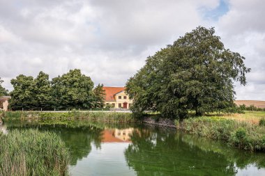 Sarı gübre hortumu Holseteinborg Kalesi, Zealand, Danimarka 'da 10 Ağustos 2021' de hendeğe yansıyor.