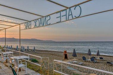 Sahile bakan turistsiz bir büfe ve gök mavisi Akdeniz, Girit, Yunanistan, 11 Ekim 2021