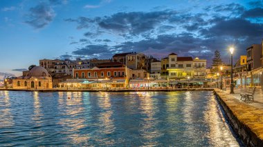 Chania Limanı 'ndaki mavi saat. Gökyüzünden ve restoranlardan yansımalarla dolu Girit, Yunanistan, 13 Ekim 2021.