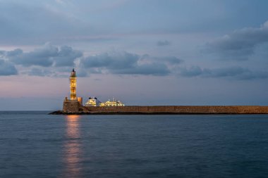 Chania, Girit, Yunanistan 'ın eski limanında 18 Ekim 2021' de bir deniz feneri ve bir yolcu gemisi.