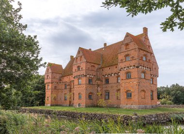 Meşhur kırmızı kale Borreby, 10 Ağustos 2021 'de Güney Zelanda, Danimarka' da bir hendekle çevrili kırmızı tuğla bir binadır.