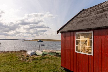 29 Mart 2022 'de Danimarka' nın Jyllinge kentinde bir balıkçı kulübesi güneş ışığıyla kıyı şeridinde açıldı.