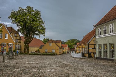 Cobbled square with roses and vintage timber framed houses in the dusk evening light, Mariager, Denmark, August 7, 2022