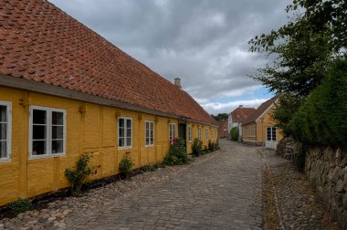 yellow half-timbered picturesque house on a cobbled street in the dansih town Mariager, Denmark, August 6, 2022