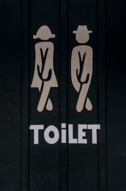 white tolilet sign on a black door showing silhouettes of a man and a woman, Denmark, August 8, 2022