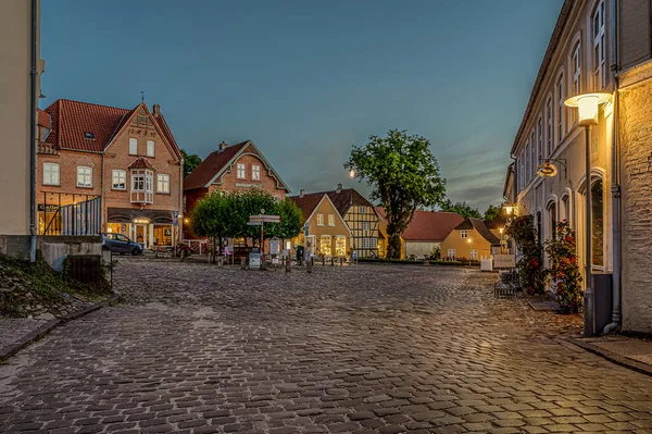 the illuminated square in the small Danish town of Mariager during the blue hour, Mariager, Denmark, August 5, 2022