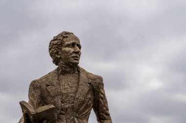 Danimarkalı şair H C Andersen 'in bronz heykeli 27 Ağustos 2022' de elinde bir kitapla parlak bir gökyüzüne karşı duruyordu.
