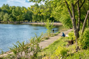 Nehir boyunca setin içinde ağaçların arasında bir kumsal var..