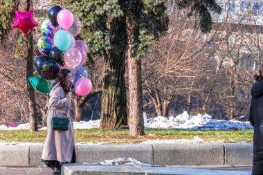 Kiev, Ukrayna - 13 Şubat 2022: Parkta balonları olan mutlu kadın.