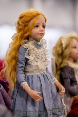 KIEV, Ukraine - September 06 ,2020: The doll looks like a real one. Girl in a simple blue dress and long red hair.