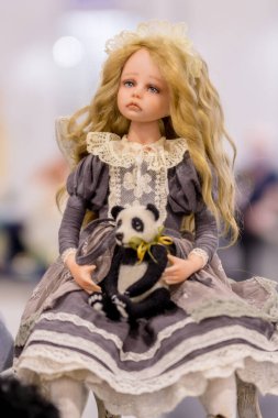 KIEV, Ukraine - September 06 ,2020: Author's doll made in the technique of realism. Toy girl holding a toy panda.