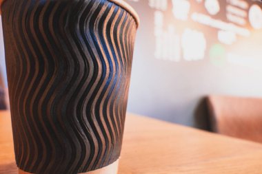 Yuvarlak kahverengi kağıt bardak masanın üzerinde duruyor..