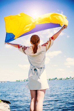 Bir kız ellerinde Ukrayna bayrağını sallıyor..