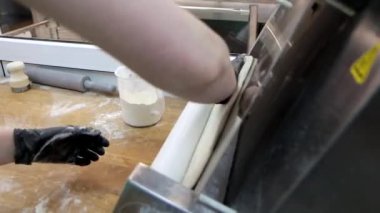 Profesyonel aşçı, özel rulo makinesini ticari mutfakta hamuru germek için kullanıyor. 4K kamera görüntüsü.