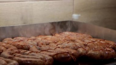The sausages roasts on the electric grill at fast food eatery