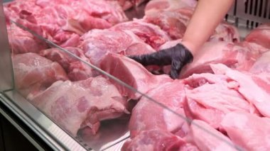 Satıcının yakın çekimi vitrine çiğ kırmızı et koyar.