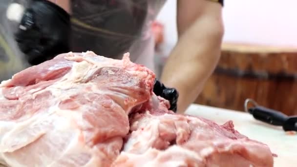 The butcher carves bones from pork body at meat processing plant. — Stockvideo