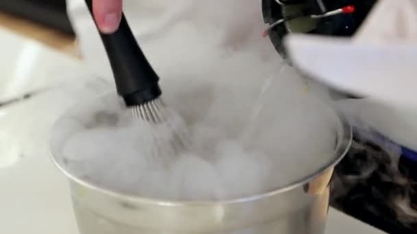 Professional chef is mixing ingredients with liquid nitrogen in steel bowl — Stock Video