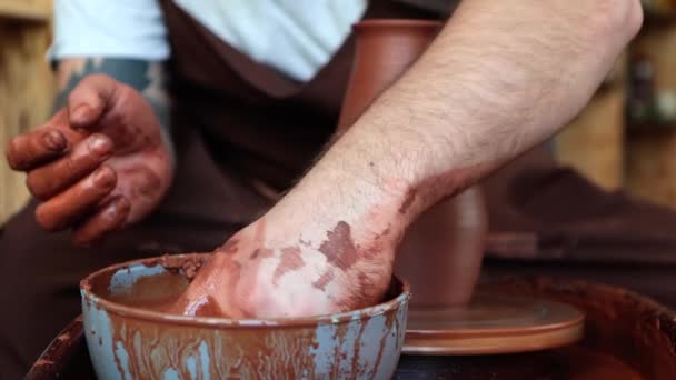포터는 도자기 꽃병을 만들고 스폰지로 닦는다 그릇에 집중하 과정을 배경에 — 비디오